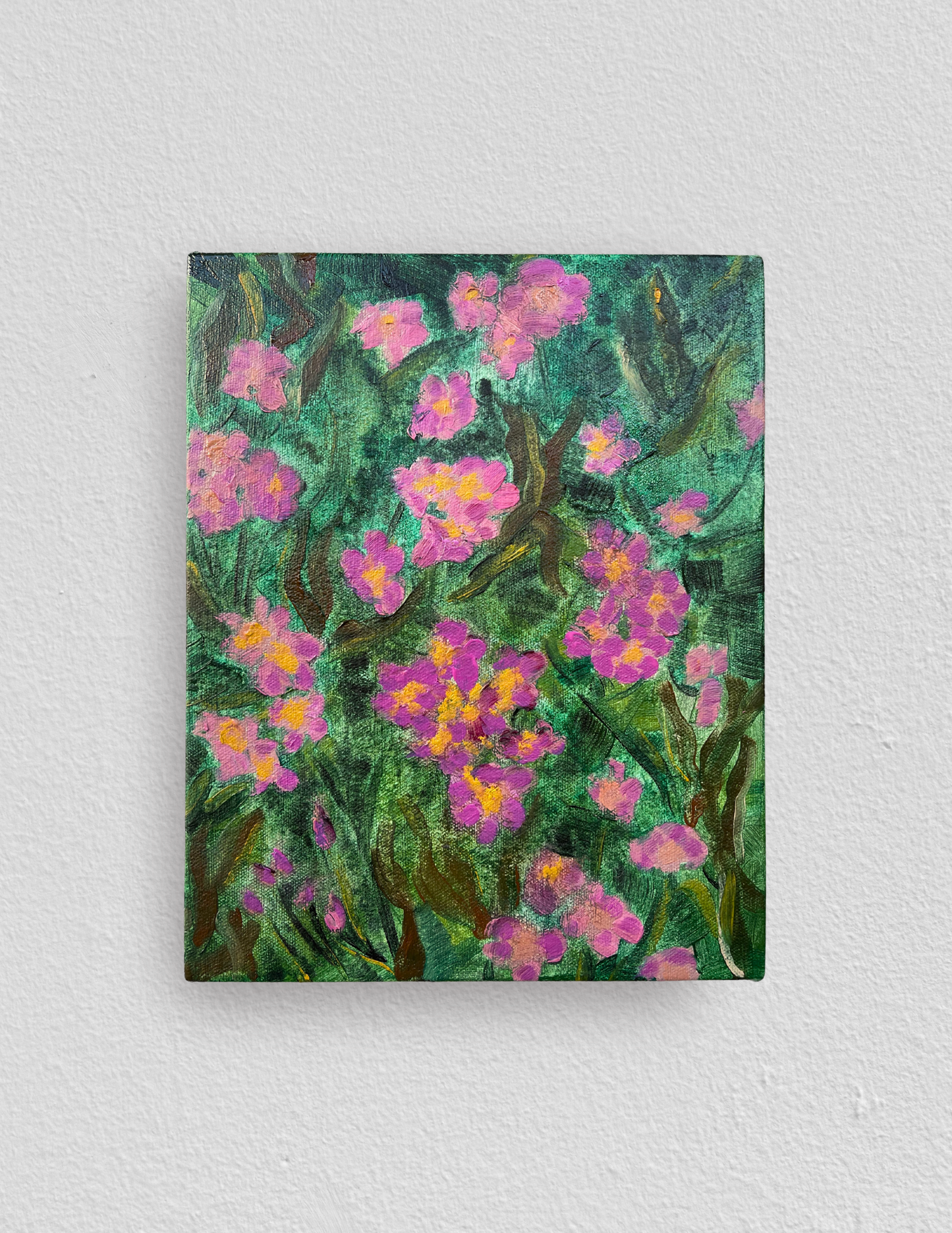 Small rectangular oil painting of clusters of tiny pink five petaled almond flowers amidst soft green leaves. 