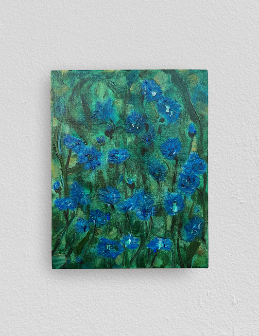 Small rectangular oil painting of semi-abstract blue cornflowers on a soft background of dreamy green foliage. 
